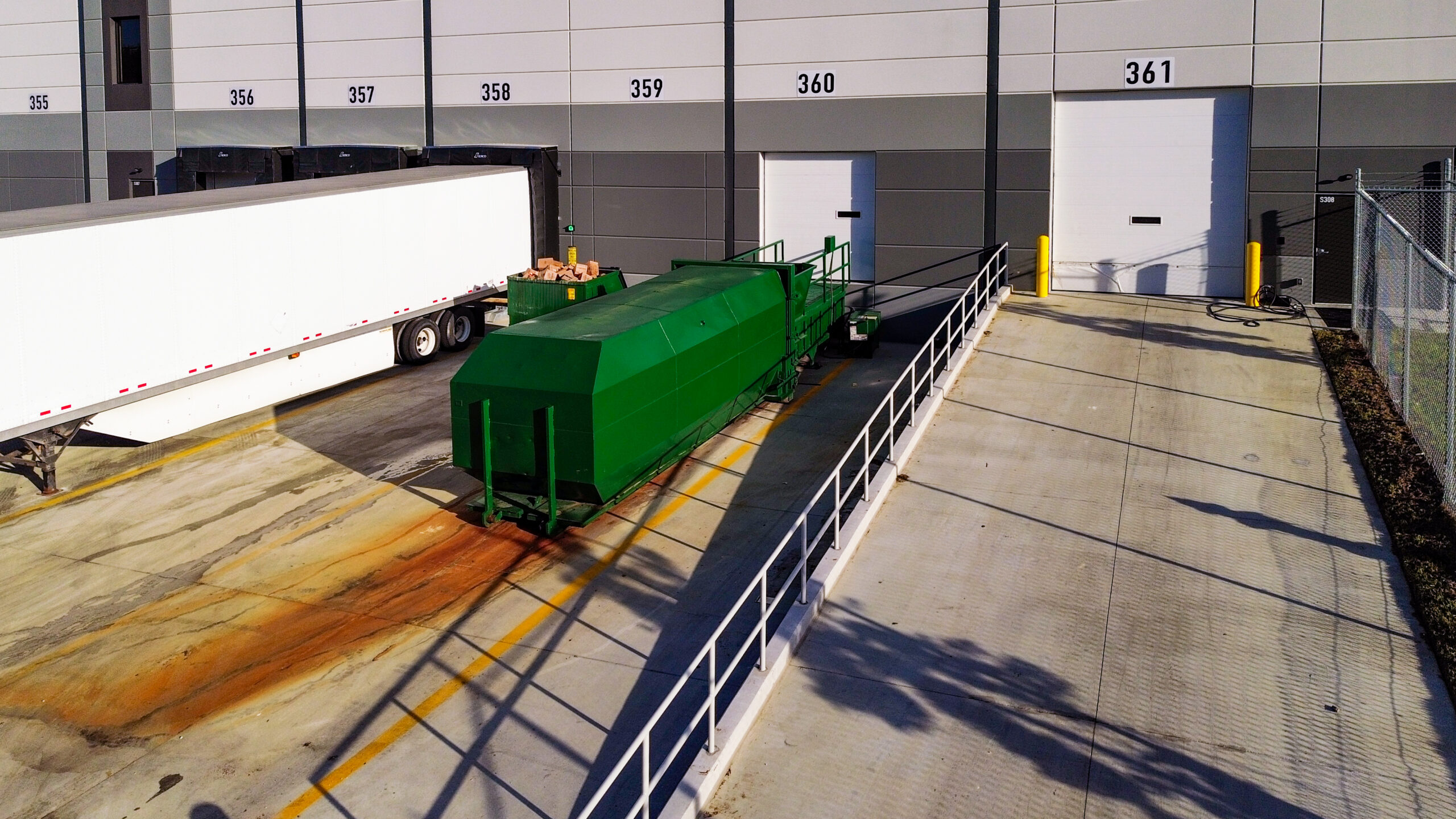 Industrial trash compactor outside warehouse, Landfill diversion.